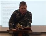 Student faces audience while sharing a poem. 